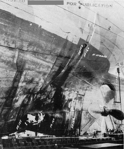 Photo 3: Torpedo damage to starboard shell, looking aft. Note wrinkle in shell plating above rupture. (U.S.S. CAPELLA).