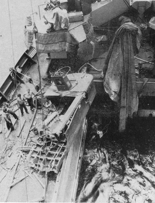 Photo 21: Damage to shelter deck, looking aft on the starboard side from No. 5 hatch. Bow of wrecked ramp boat has been removed. 