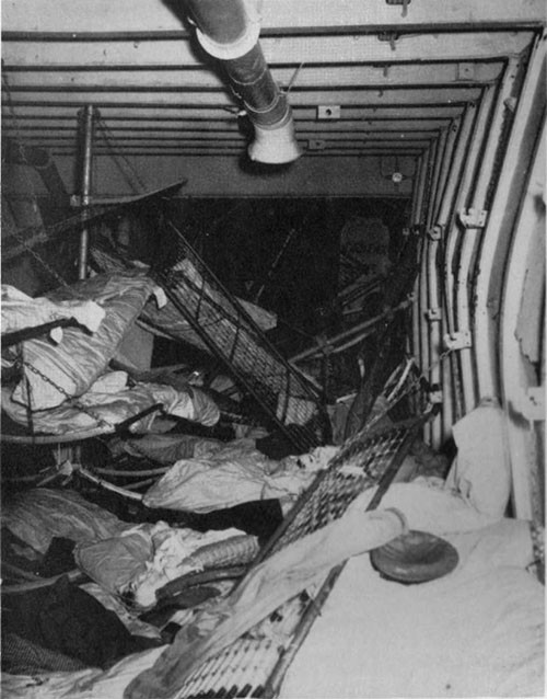 Photo 26: Damage to crew's quarters starboard side second deck, looking aft from forward edge of No. 5 hatch. 