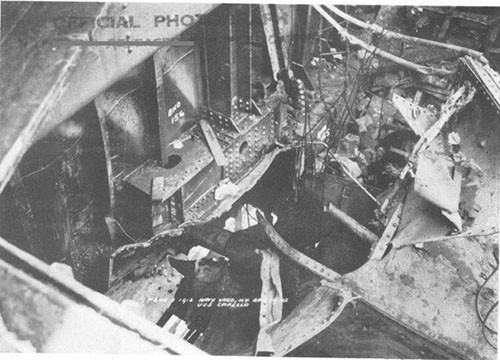 Photo 9: Blast damage to bulkhead 155, first platform and shaft alley top in the after end of No. 5 cargo space. Note riveted joint failures. (U.S.S. CAPELLA).