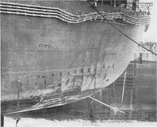 Photo E-19: Near-miss. View of counter showing near-miss damage. Note near rupture of shell in way of third deck and degaussing cable clips sheared from shell.