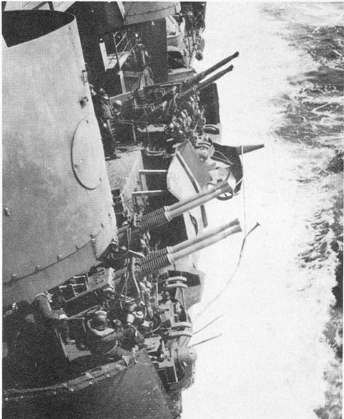 Photo I-1: First near-miss. 40mm mounts Nos. 8 and 10, frame 150 port, showing gun sponson shields sheared off by plane. Protruding pipe line is gasoline main drain.