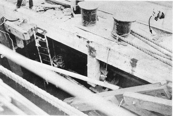 Photo No. 1: Dock showing location of bomb hole, to right of mooring bitts. Oil and water piping under the dock was bent and ruptured.