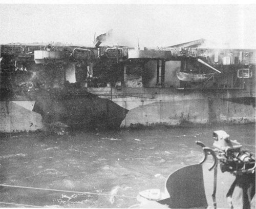 View of after port side of PRINCETON. Note hangar roller curtains demolished, panel between frames 110 and 113 blown out and hole in panel between frames 115 and 118.
