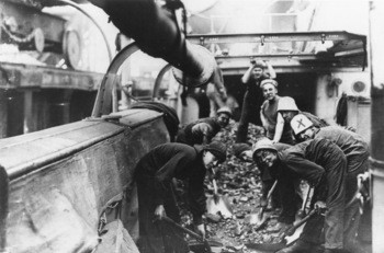 A picture of sailors shoveling coal.
