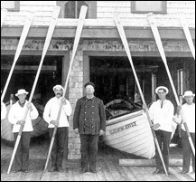 A picture of surfmen with oars and their boat; they were a part of the Coast Signal Service. They are now known as lifesavers.