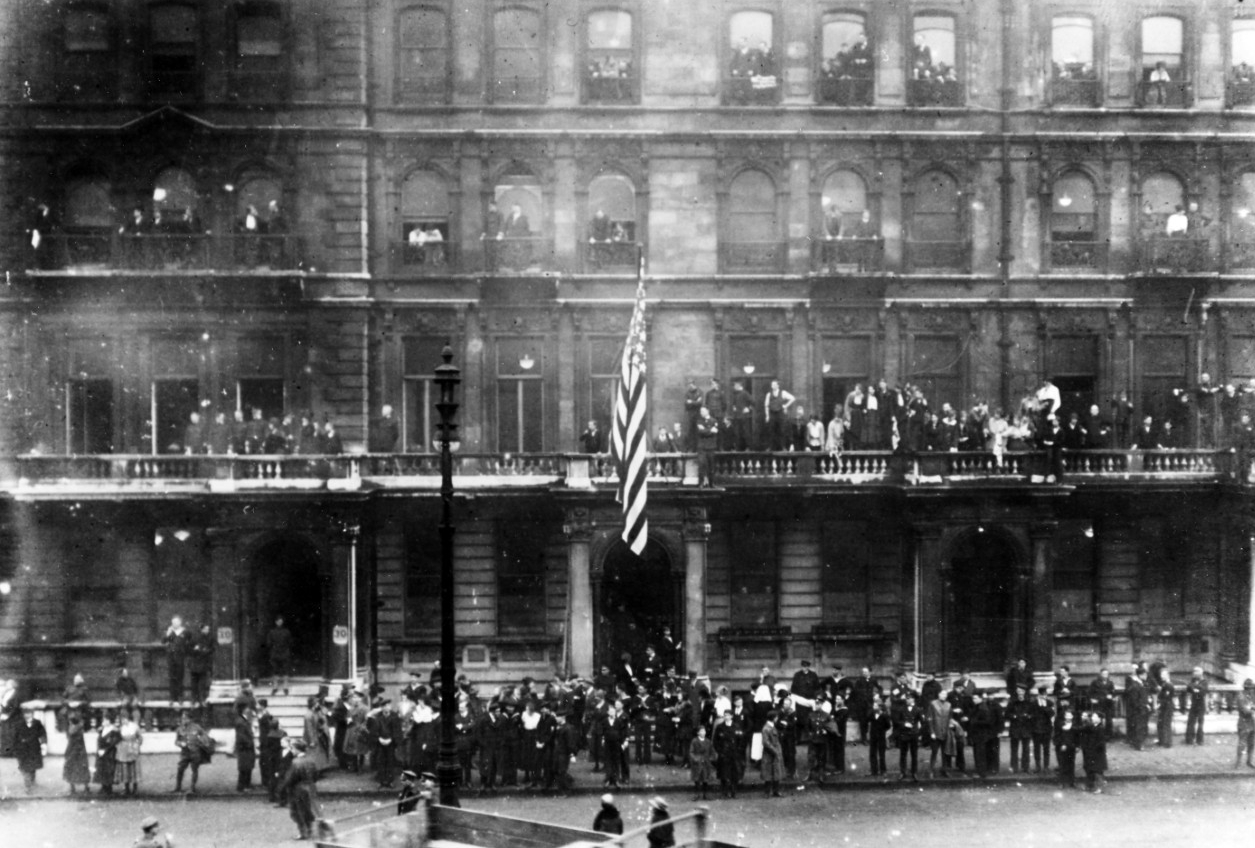 Photograph of crowd gathered on the street outside a large building
