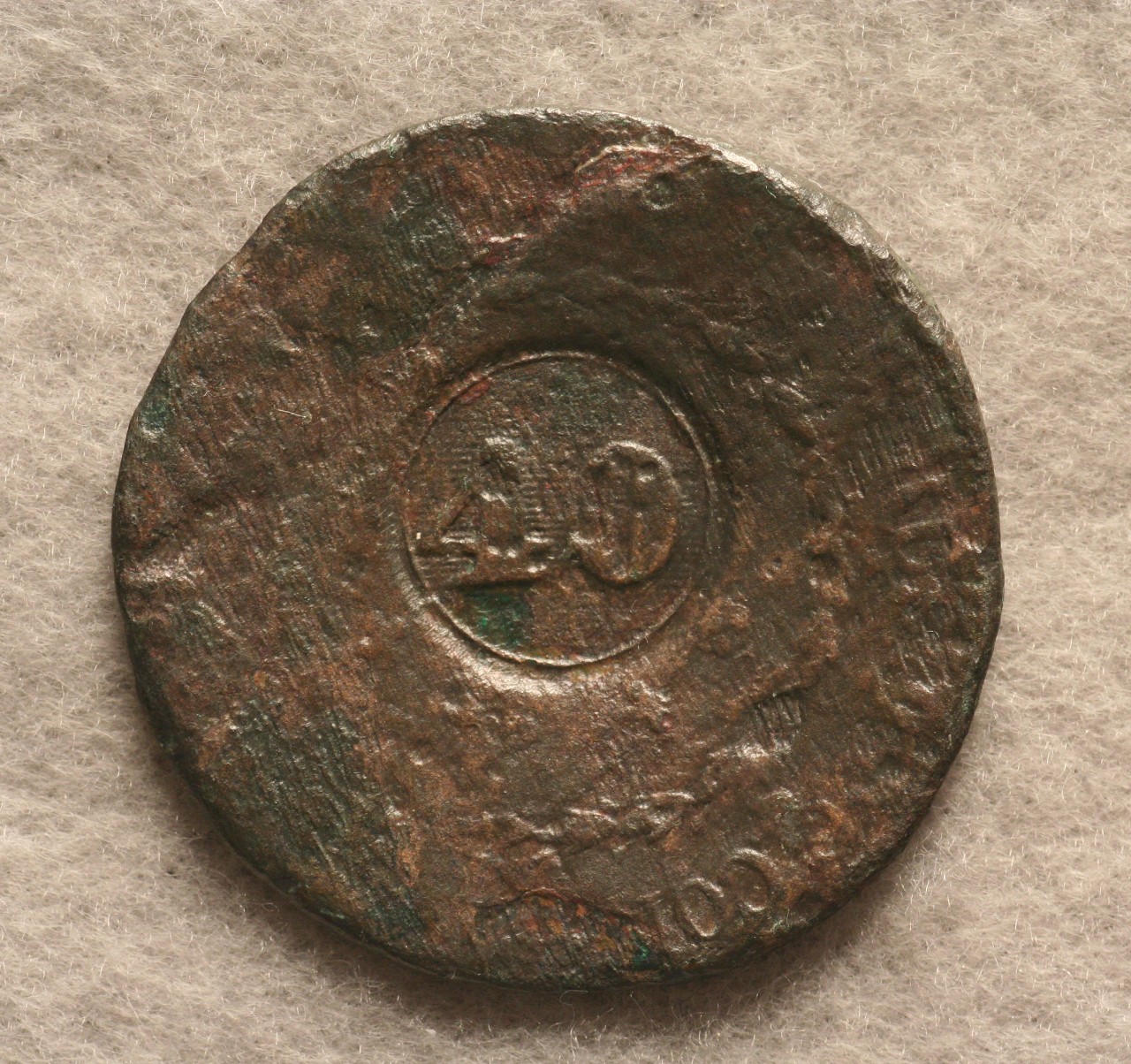 <p>A round bronze Brazilian 40-Reis coin recovered from the CSS Alabama. On the reverse side is a faded crown on top of a faded shield that is surrounded by garland. This coin was produced during the reign of King Pedro I of Brazil.</p>