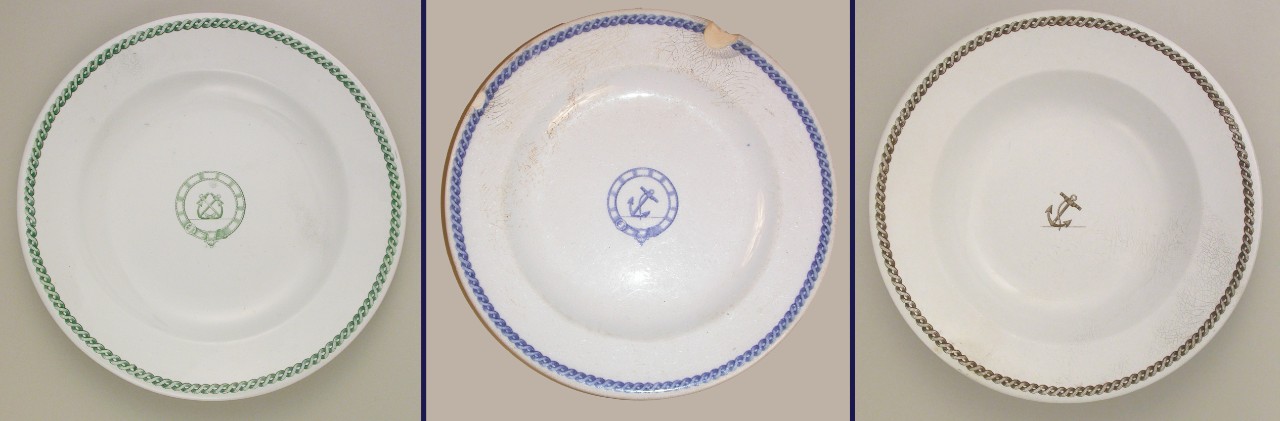 Examples of white, circular Davenport plates from CSS Alabama with a blue, green, or brown decorative printed on each one.  One plate has a blue anchor in the center surrounded by a looped belt and a blue twisted rope design around the plate’s edge.  Another plate has two green anchors crossing each other surround by a looped belt in the center and a green twisted rope design around the edges.  The other plate has a brown anchor in the center of the plate with a brown twisted rope design around the plate’s edge.