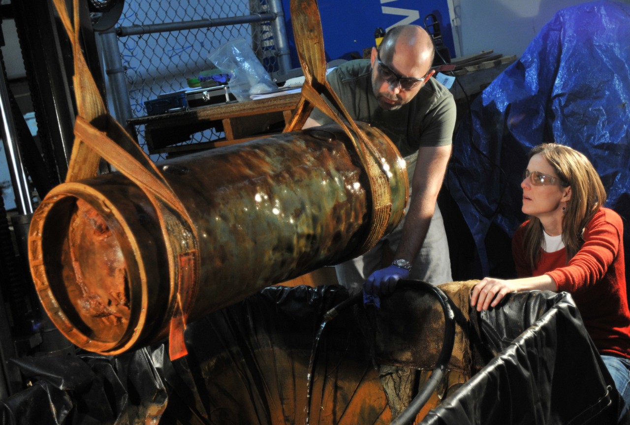 Paul Mardikian and Claudia Chemello, from Terra Mare Conservation, use a forklift to raise the middle body of the Howell Torpedo to document the preservation state to develop a conservation plan for the artifact.