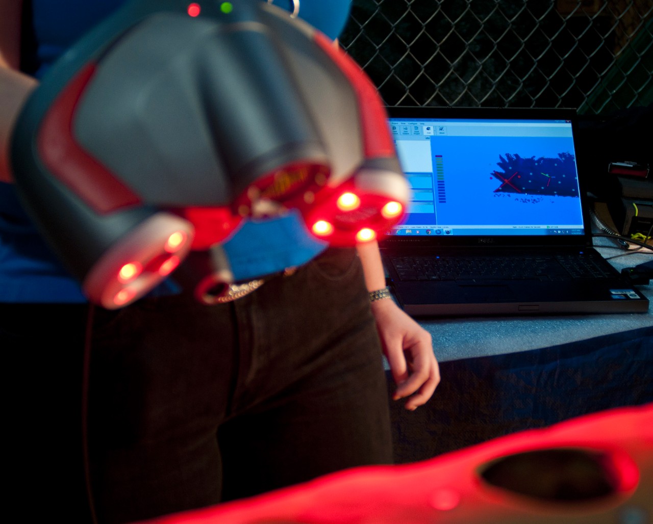 A project engineer uses a hand-held laser scaner to move over the midsection of the Howell Torpedo to generate 3-dimensional rendering on the laptop in the background. 