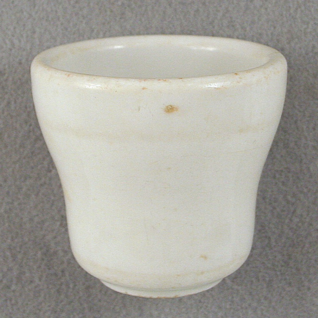 <p>An undecorated white glazed stoneware cup from USS San Diego.</p>
