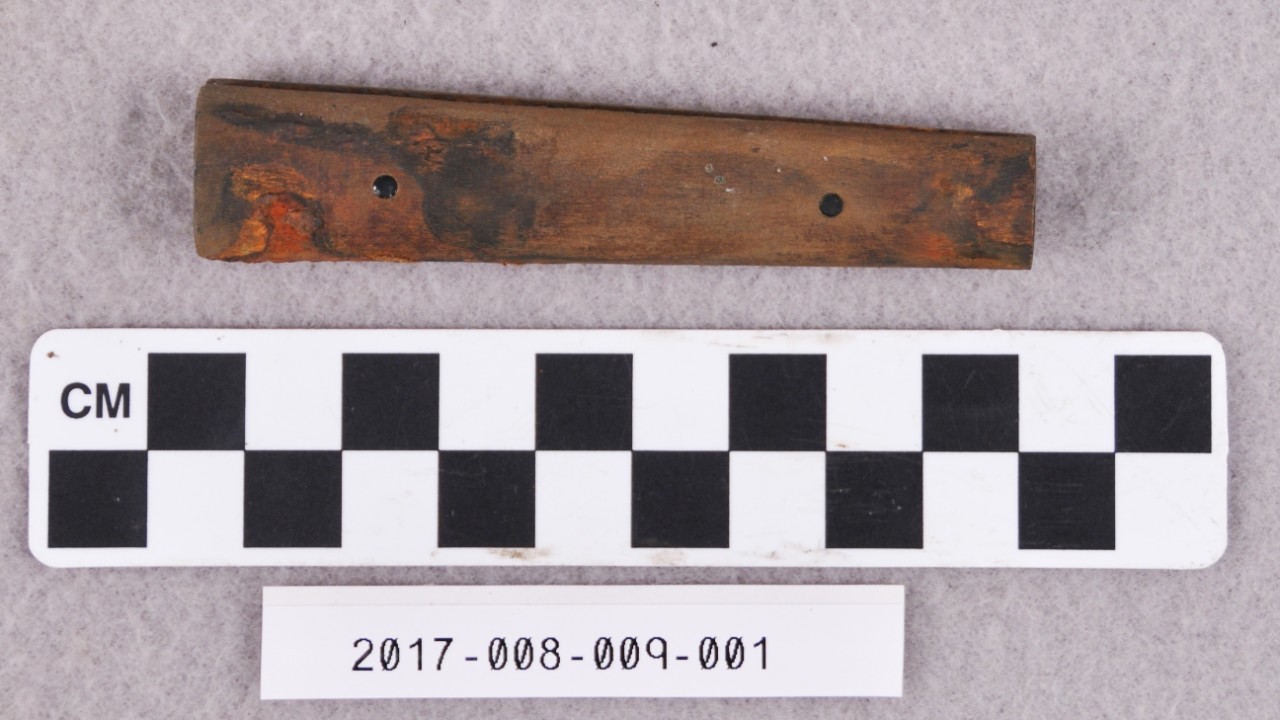 <p>An undecorated wooden handle of a folding knife. It is made up of two pieces of wood connected by two pins. A partial iron blade is located inside the wood, not seen in picture.</p>
