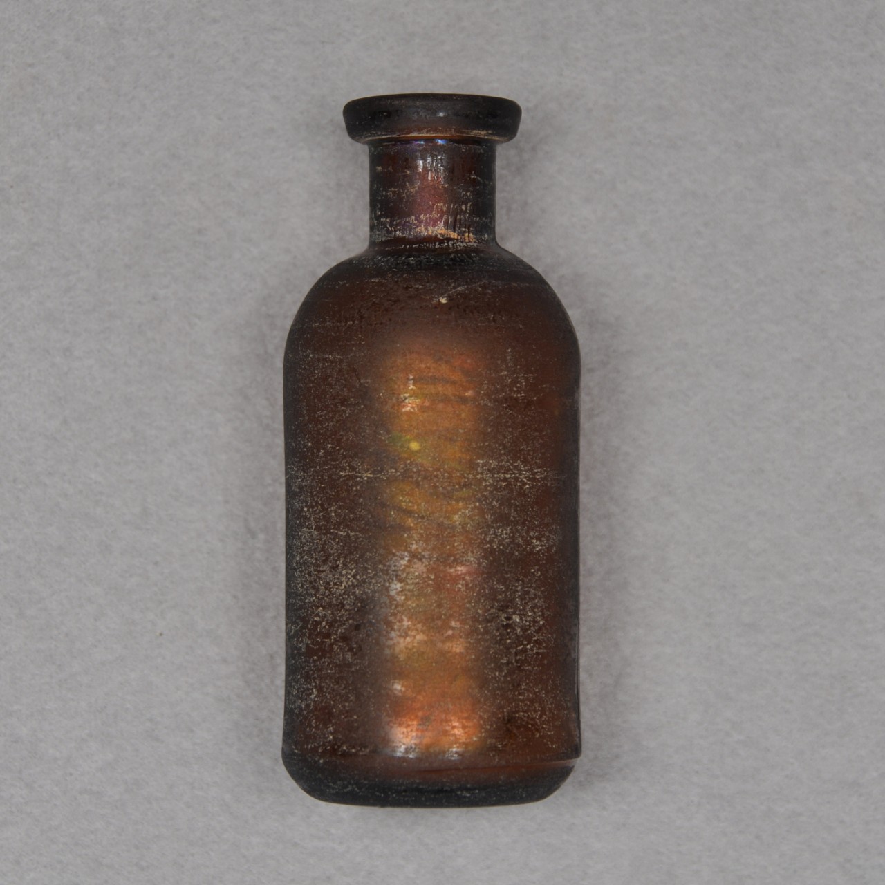 <p>A small, undecorated non-screw top brown glass bottle.</p>

