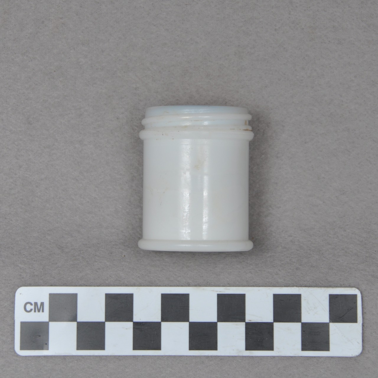 <p>A small, white, round screw-top container. Sttamped&nbsp;on the bottom is “MENTHOLATUM REG TRADE MARK” (not seen in photo).</p>
