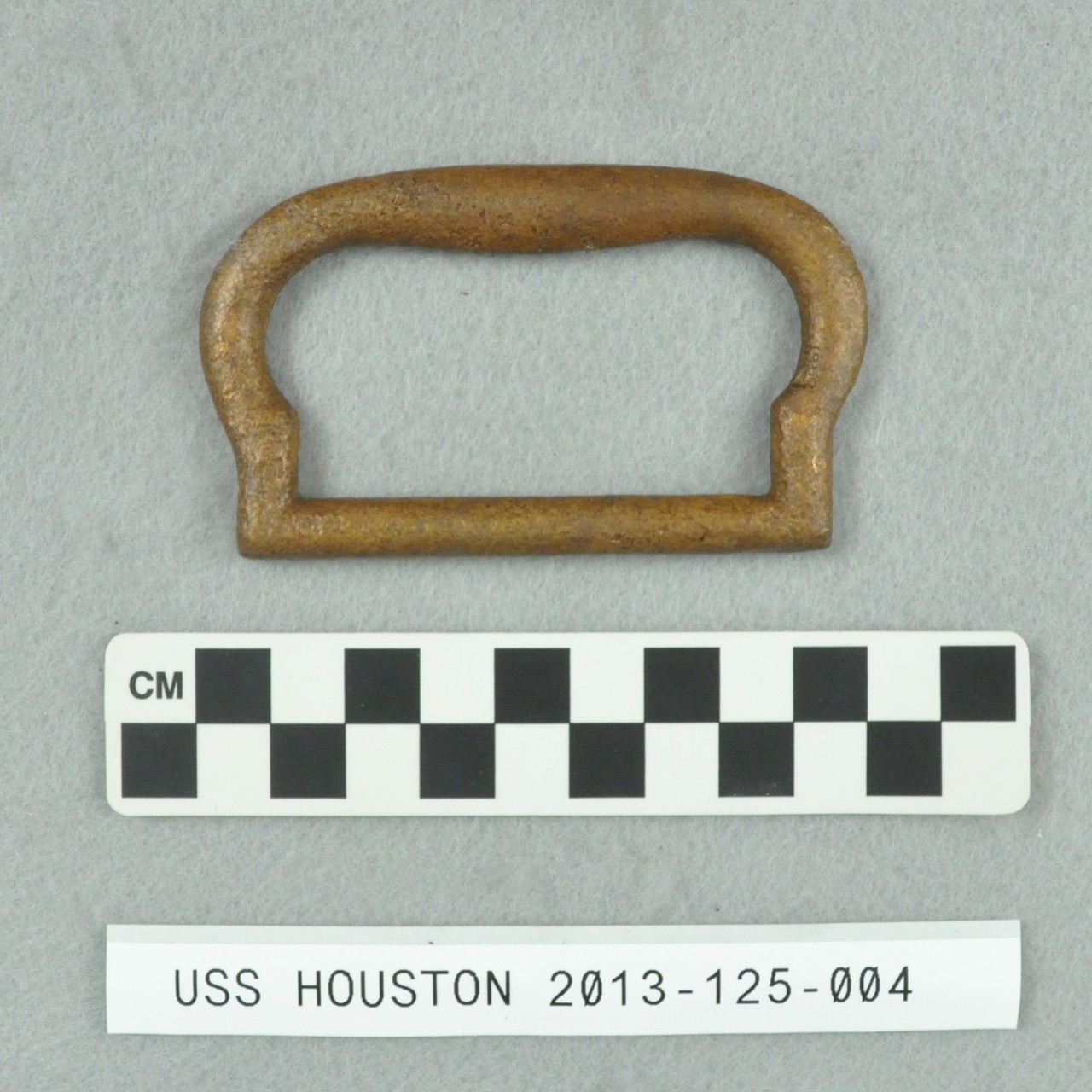 <p>A rectangular shaped brass fitting from USS <i>Houston</i>.</p>
