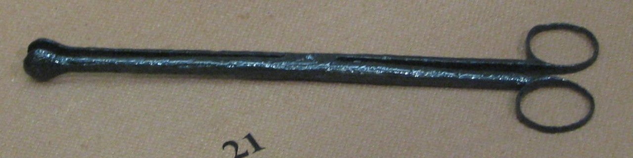 Iron forceps with long, thin shank and straight jaw that is cupped at the tip.