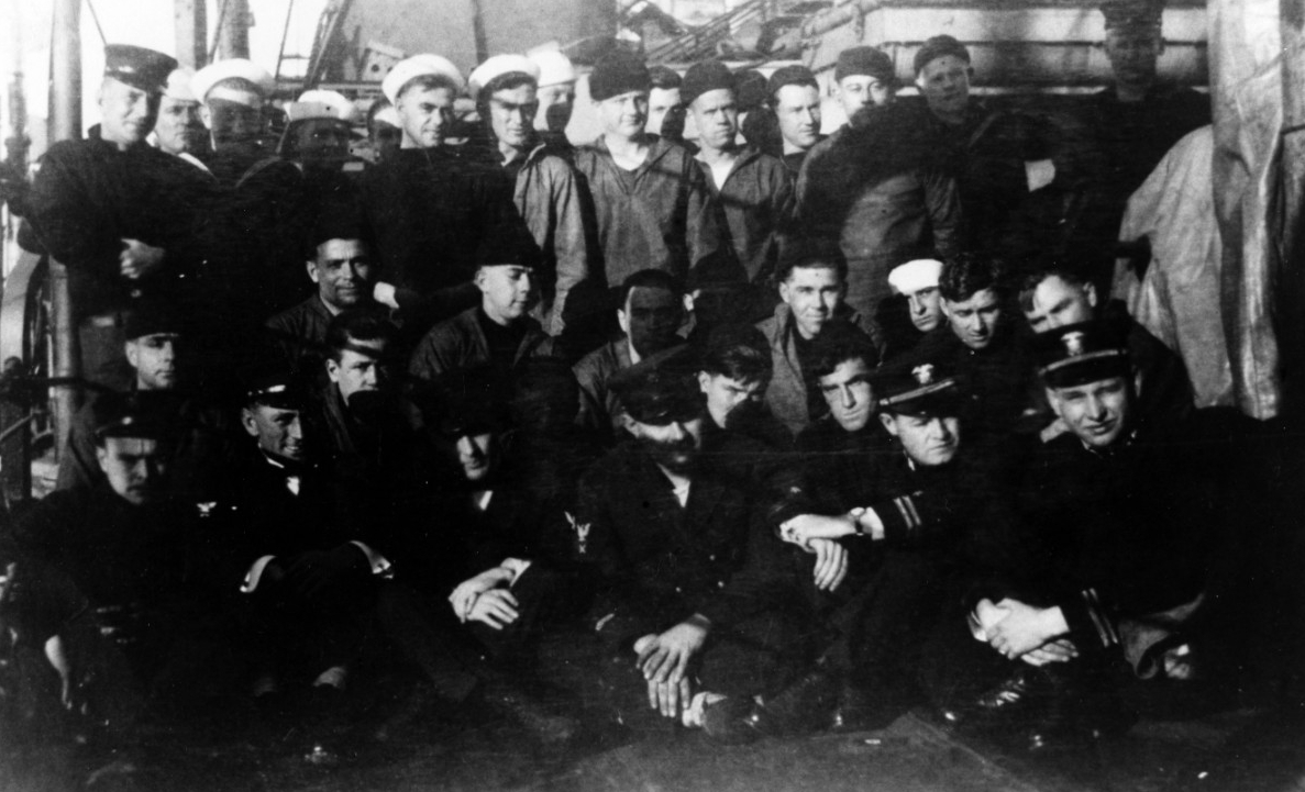 Black and white image of US Navy sailors on a ship deck. These sailors were just rescued from the sinking USS Jacob Jones.