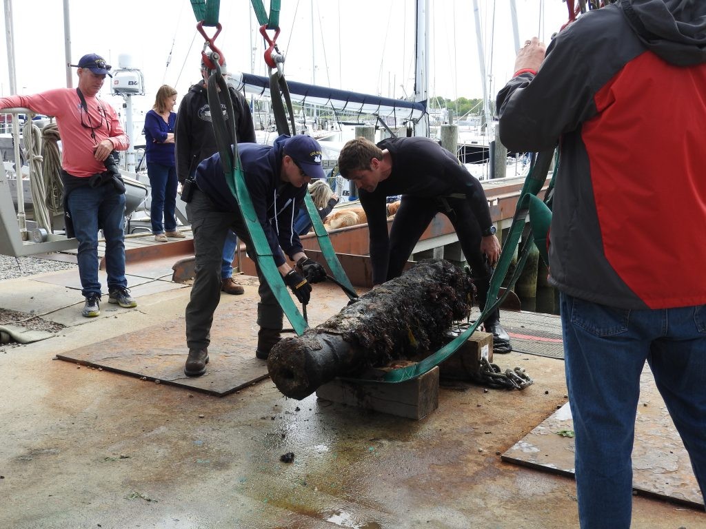 Photo of Schwarz and Faloon examining lifting straps on a cannon recovered from the suspected USS Revenge site prior to transport.