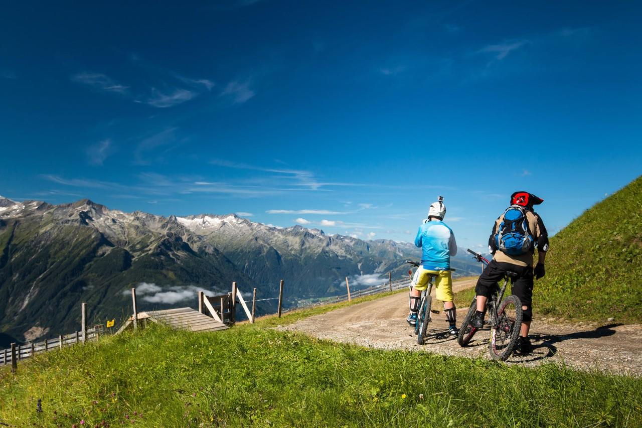 Group of mountain bikers riding an enduro trail in the austrian alps in salzburg near Kaprun